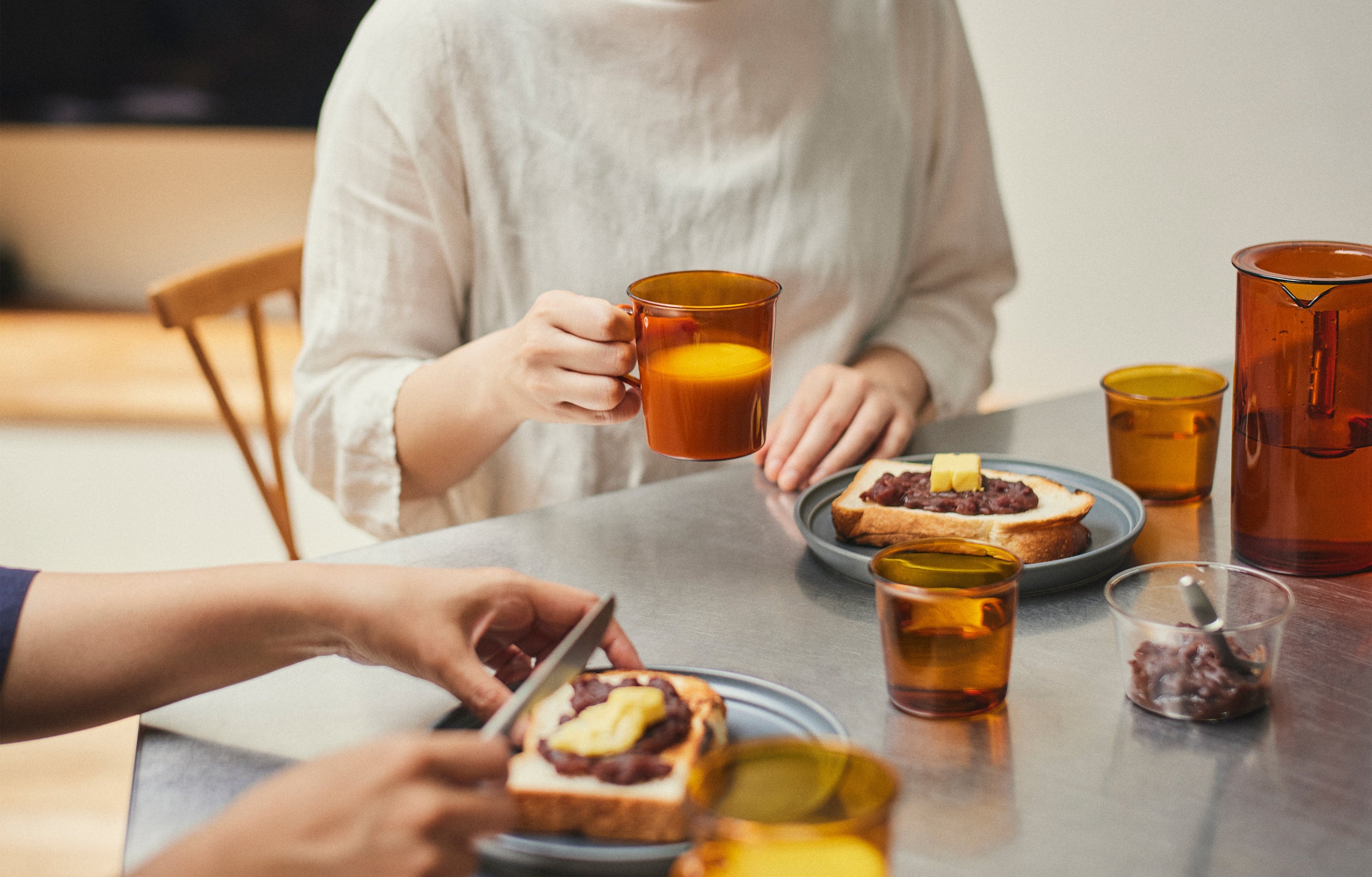 Two people enjoying a meal together with toast and drinks at a table.